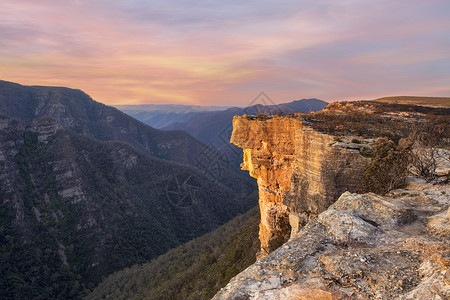 巨大的悬崖壁和深峡谷与日落天空的景象背景图片