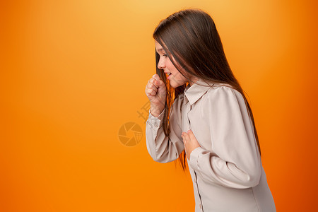 身着临时穿衣 感觉不舒服和在橙色背景下咳嗽的少女衣服病人女士过敏感染女性保健工作室卫生发烧肺炎高清图片素材