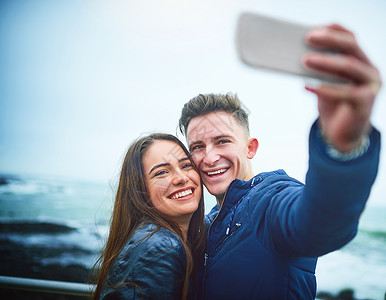 约会第一张自拍 一对快乐的年轻夫妇在户外玩自拍的照片背景图片