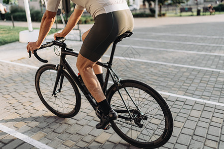 男人骑自行车夏间骑自行车的户外近距离靠近自行车手背景