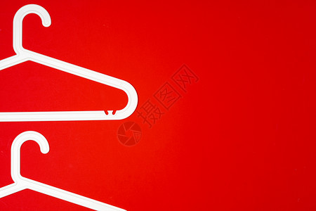 红色纸面背景的挂衣架 最小时尚概念 顶部视图精品金属塑料零售架子衣帽间店铺休闲装销售外套背景图片