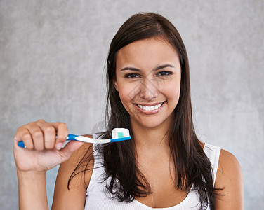 照顾我的珍珠白 一位年轻女子快乐地刷牙的孤立画像背景图片