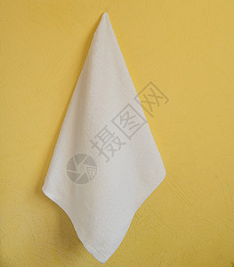 浴室挂毛巾挂在黄墙上的白纸巾淋浴纺织品家庭白色酒店按摩材料织物浴室治疗背景