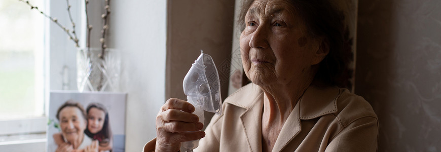 身戴医疗呼吸面具的老年妇女近距离肖像 掌声过敏流感情况喷雾器呼吸药品女性长老退休感染背景图片