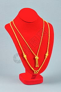 颈带展台和金项链在灰色背景上金色财经魅力支架织物宝石个人衣领礼物吊坠背景图片