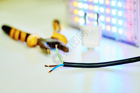 电钳子有棕色蓝色和绿黄色导线的黑电线 钳子手电筒背景