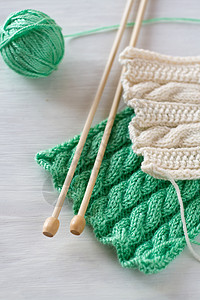 两种亮光图案和白色背景的木编织针头线程针织爱好绿色配饰背景图片