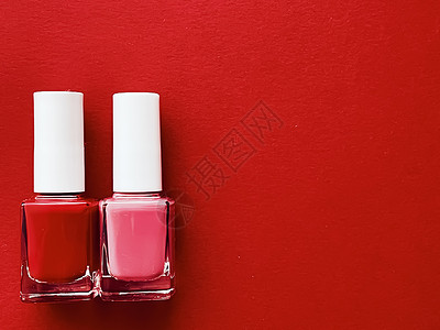 红底 修指甲和美容化妆品上的红色和粉红色指甲油瓶玫瑰玻璃粉色抛光沙龙美甲平铺瓶子背景图片