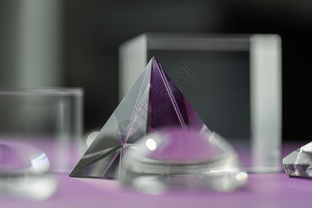 小三角形紫色背景的水晶棱镜折射光 魔法水晶和金字塔 球体和立方体 修行灵疗水晶 风水 良好的能量流概念背景风格橙子辉光太阳仪式装饰玻璃光背景