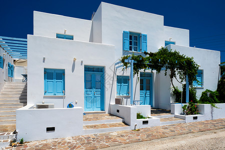 传统的希腊传统建筑房屋漆白白色 有蓝色门和窗帘的玻璃细节街道出口窗户建筑学村庄百叶窗入口背景图片