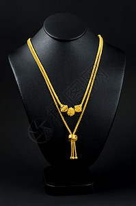 颈项展台和金项链 在黑色背景上金链财经奢华颈部衣领宝石金色对象金属支架背景图片