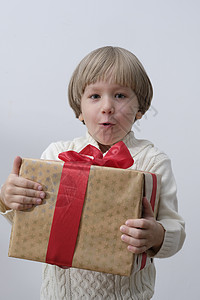 带着圣诞礼物盒的惊喜孩子 白背景男孩 新年和X-mas概念背景图片