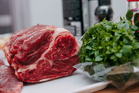 在烹饪课上煮牛排的老牛肉 生牛肉和绿菜 特制眼睛厨房宏观桌子食物迷迭香牛扒餐厅草本植物肋骨背景图片