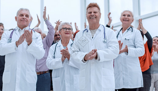 医生和一群成熟的病人鼓掌欢呼女士卫生检查外科团队男人疾病讨论专家保健背景图片