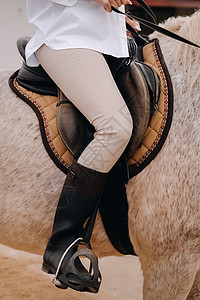 骑马者腿上插着搅拌机的接缝马术动物骑术良种马镫皮革周长冠军骑师小马背景图片