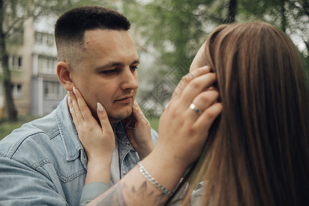 一个男人崇拜他的女朋友 调整她的头发 看看那个家伙背景图片