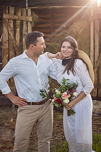 穿着牛仔风格的新娘 坐在干草地的门槛上背景图片