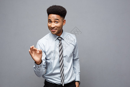 商业概念-自信的快乐年轻非裔美国人在他面前举起手来 在灰色背景上以令人惊讶的表情向他展示友好的高清图片素材