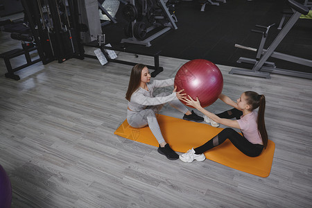 女青少年在体育馆锻炼健身运动服务腹肌女士腹部运动员女孩力量培训师背景图片