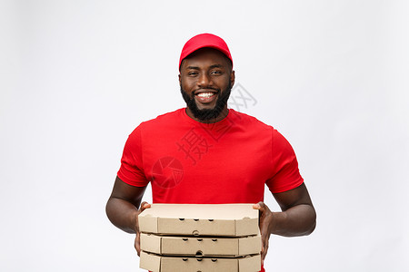 交付概念  英俊的非洲裔美国人披萨运送者的肖像 孤立在灰色工作室背景上 copy space手指盒子相机工人服务男生邮递员商业男背景图片