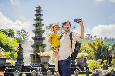 爸爸和儿子游客在 水上宫殿 水上公园 印度尼西亚巴厘岛 带着孩子旅行的概念 儿童友好的地方喂鱼高清图片素材