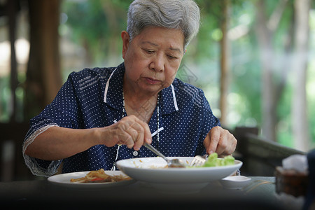 年长的高级妇女在露台上吃食物 成熟的退休生活方式午餐老年早餐公园祖母女士女性花园阳台背景图片