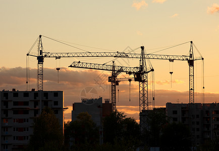 日落时建筑工地房屋起重机背景图片