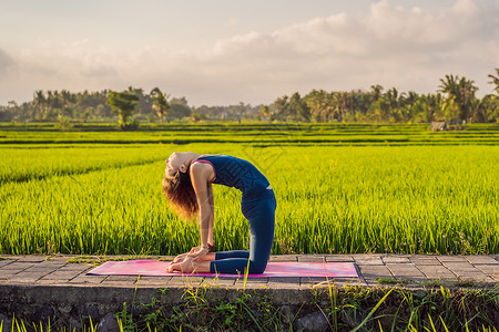 年轻女性在巴厘健康务虚会当天早上在稻田户外做瑜伽姿势公园潮人专注手印沉思女孩稻田冥想活动背景
