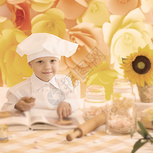 快乐的小男孩 一个书厨师在包里准备早餐背景图片