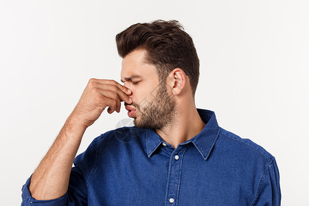 男人用鼻子抵挡灰色背景的臭气味 他被孤立在灰色背景上手指进攻香气气体成人恶臭白色男性厌恶鬼脸恶心高清图片素材