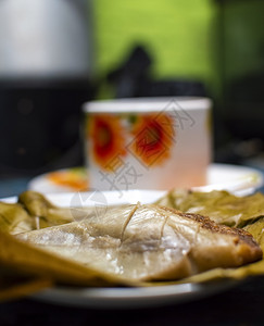 木制餐桌 香蕉叶上塞满的塔马人 木制餐桌 典型的尼卡拉瓜食品面包早餐盘子食物叶子蒸肉玉米烹饪美食背景图片