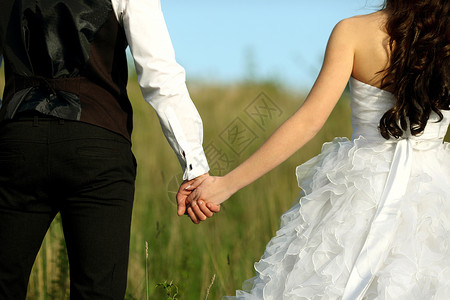 穿着白色礼服的新娘和身穿西装的新郎后视镜 将双手举起在户外婚姻女士男性婚纱裙子婚礼男人生活仪式庆典订婚高清图片素材