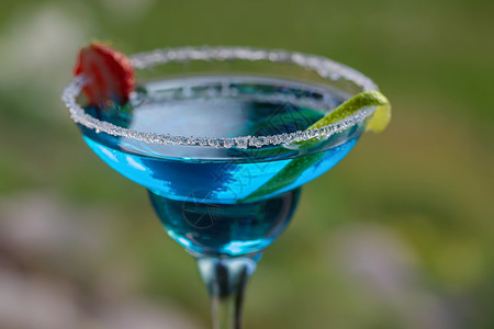 玻璃杯加蓝色玛格丽塔鸡尾酒 有选择性地聚焦点 加柠檬和草莓酒吧玻璃液体异国饮料情调酒精果汁水果照片背景