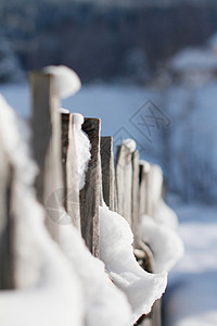 景深木栅栏在雪盖的木篱芭特写镜头有焦点背景的 前景中的散景背景和雪背景
