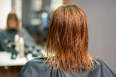 湿润长红头发的后视女性服务美容师理发师染色理发顾客治疗沙龙女孩时尚高清图片素材