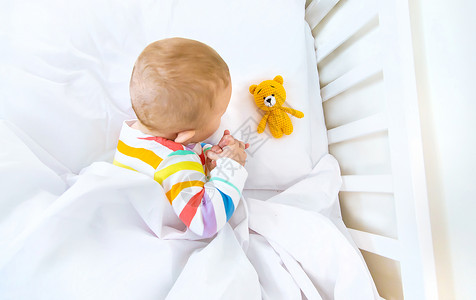 婴儿床里的婴儿上床睡觉 有选择地集中注意力蓝色孩子玩具女士母亲横幅卧室毯子房间男生背景