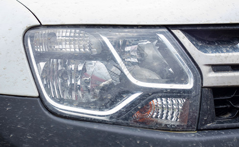 汽车LED大灯雷诺 Duster 右前大灯 带有黑色保险杠的白色跨界车或 SUV 汽车前视图 汽车上的详细特写灯 外部细节 乌克兰 基辅 -背景
