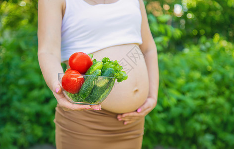 孕妇手里拿着蔬菜 有选择的专注点肚子沙拉家庭厨房福利营养父母女性生活横幅产前高清图片素材