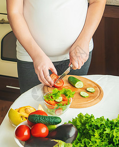 孕妇吃蔬菜和水果 有选择性地集中注意力营养素食主义者厨房女孩横幅婴儿父母饮食腹部女性家高清图片素材