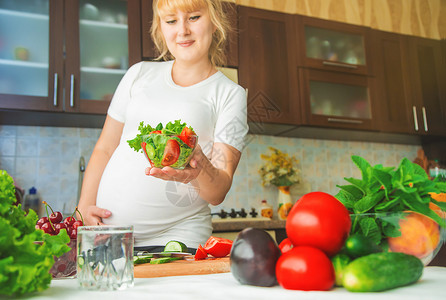 孕妇吃蔬菜和水果 有选择性地集中注意力女性怀孕女孩沙拉女士腹部婴儿营养素食主义者母亲饥饿的高清图片素材