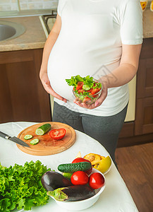孕妇吃蔬菜和水果 有选择性地集中注意力横幅女孩父母营养沙拉成人腹部怀孕母性素食主义者厨房高清图片素材