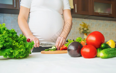 孕妇吃蔬菜和水果 有选择性地集中注意力母亲沙拉母性成人父母厨房素食主义者营养怀孕肚子美丽的高清图片素材