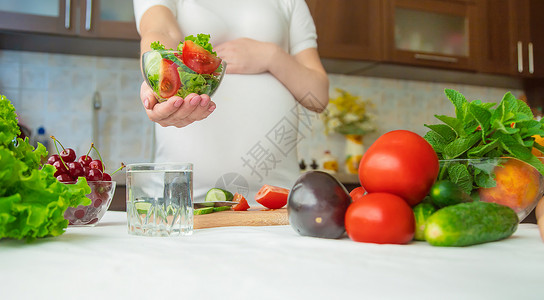 孕妇吃蔬菜和水果 有选择性地集中注意力饮食女士沙拉怀孕肚子横幅母亲女性母性腹部营养高清图片素材
