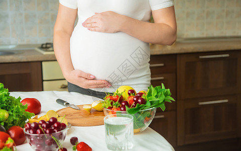 孕妇吃蔬菜和水果 有选择性地集中注意力女性饮食素食主义者肚子腹部母性母亲怀孕父母营养厨房高清图片素材