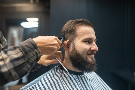 理发店主用剪发机给男人理发修剪胡须男性商业客户剪刀剪子工具理发师造型师职业高清图片素材