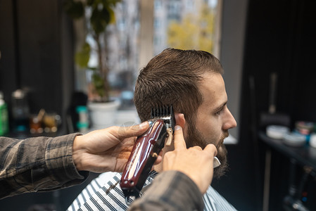 理发店主用剪发机给男人理发成人剪子男性发型设计发型师剪刀客户商业造型师沙龙职业高清图片素材