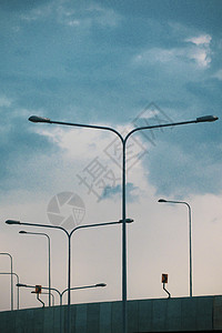 一排街灯/灯映衬着蓝天 LED道路照明 道路照明灯杆 很多路灯映衬着蓝天 带灯的金属杆 道路建设背景图片