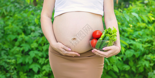 孕妇手里拿着蔬菜 有选择的专注点肚子母亲成人父母幸福家庭营养食物母性厨房横幅高清图片素材
