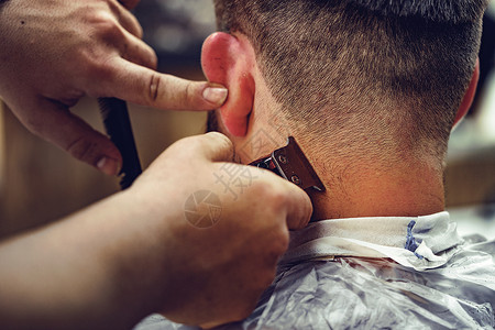理发师给在理发店坐在椅子上 长胡子的男人理发胡须头发成人店铺发型商业沙龙职业服务工具微调器高清图片素材