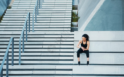 全程扶持检查她的进度 全程拍摄 一个有吸引力的年轻女运动员在城外锻炼活动的照片背景
